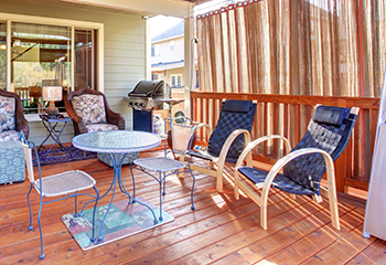 Beautifully remodeled porch with hardwood flooring in Manhattan Beach, featuring comfortable seating and a scenic backyard view.