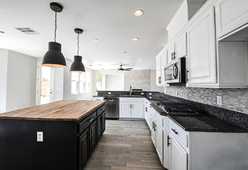 Modern kitchen design featuring a large island, sleek cabinetry, and high-quality tile backsplash in Hermosa Beach.